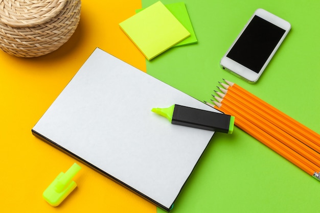 Blank paper with smart phone on desk.top view,flat lay