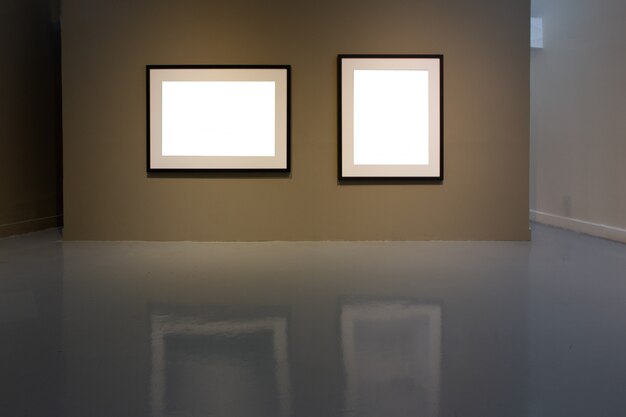 Blank photo frame on golden wall in art gallery.