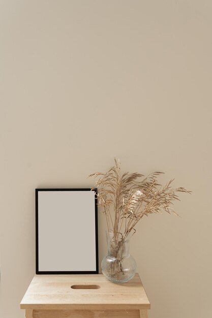 Photo blank photo frame with empty copy space and dried grass bouquet on neutral background