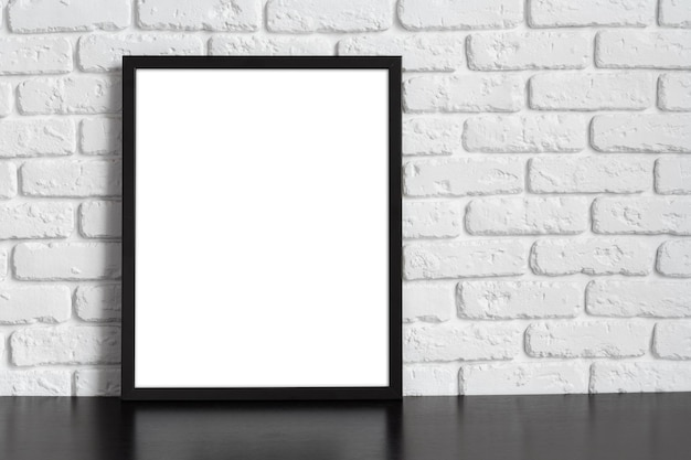 Blank picture frame against brick wall with copy space