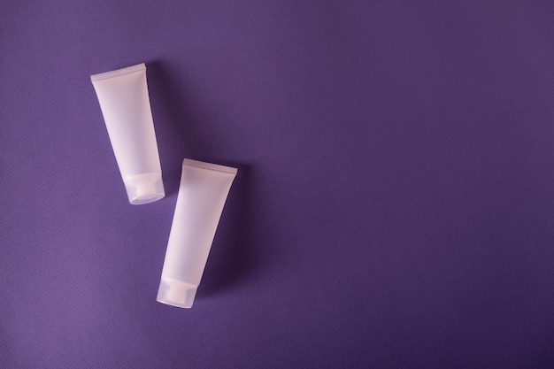 Blank plastic Cosmetic tube mockup as package for cream or lotion on purple background