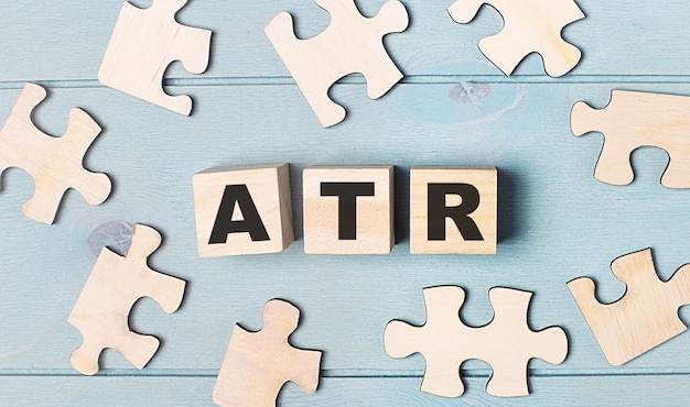 Blank puzzles and wooden cubes with the text ATR Average True Range lie on a light blue background