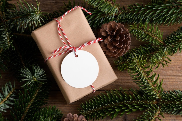 Blank round Christmas gift tag mockup with present box product label mockup with natural fir tree branch