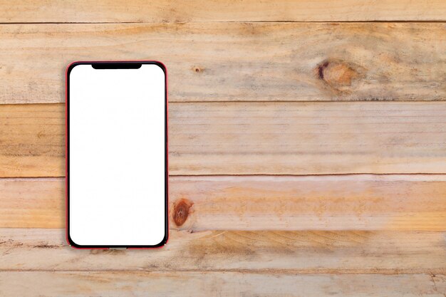 Blank screen mobile phone on wooden table.