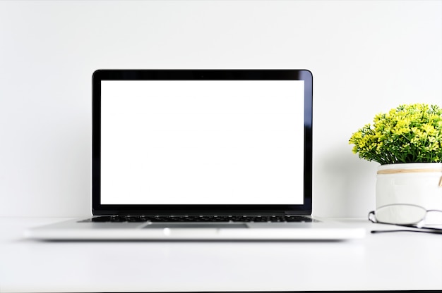 blank screen Modern laptop computer with mouse,Smart phone and Succulent on wood table in office background