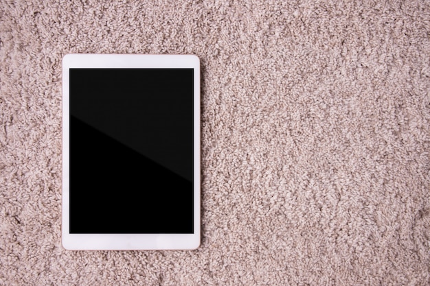 Blank screen on tablet, cell phone on carpet