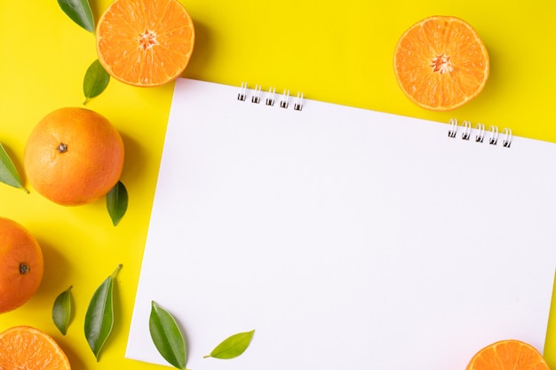 Blank screen on white paper and orange fruit.