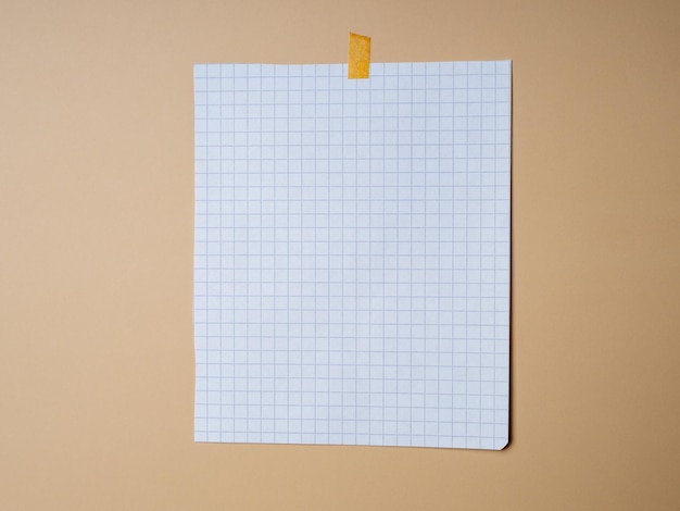 A blank sheet of checkered paper on a beige background