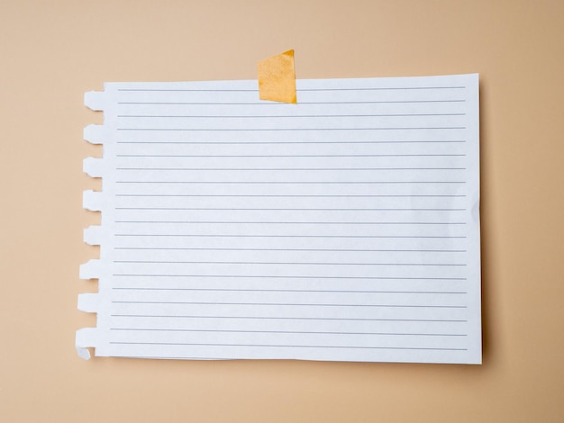 Blank sheet of paper with stripes taped on a beige background