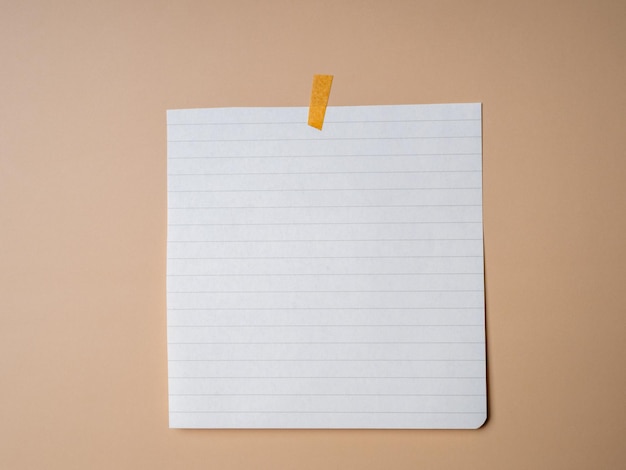 Blank sheet of paper with stripes taped on a beige background