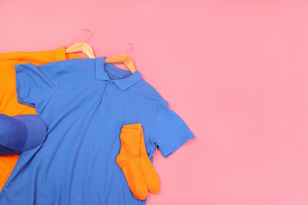 Blank t-shirts, socks and cap on pink background