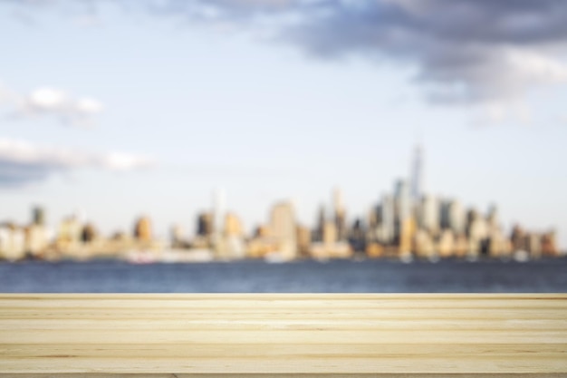 Blank tabletop made of wooden planks with beautiful blurry cityscape in the afternoon on background mockup