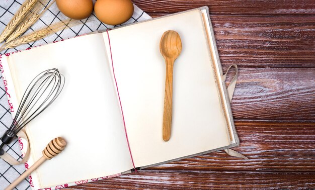 Photo blank vintage recipe book eggs and spoon on the wooden background top view place for text banner