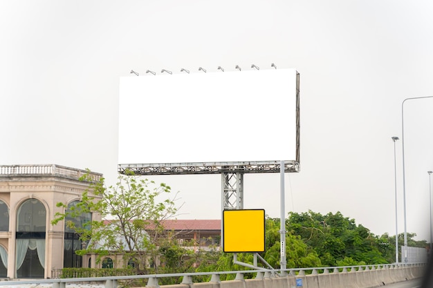 Blank White Billboard with Blue Sky Clouds and Trees focus on blank big billboard on highway in city town Bangkok