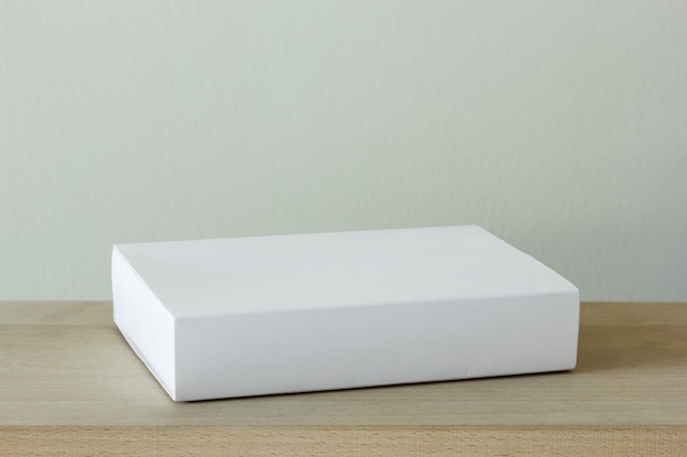 Blank white cardboard package box on wooden table