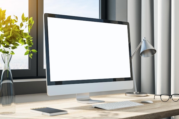 Blank white computer monitor screen on table in office