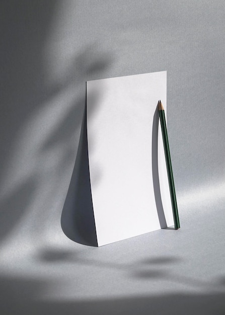 Blank white greeting card or note with foliage shadow on gray background