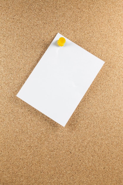 Blank white note papers is pinned to a cork board.