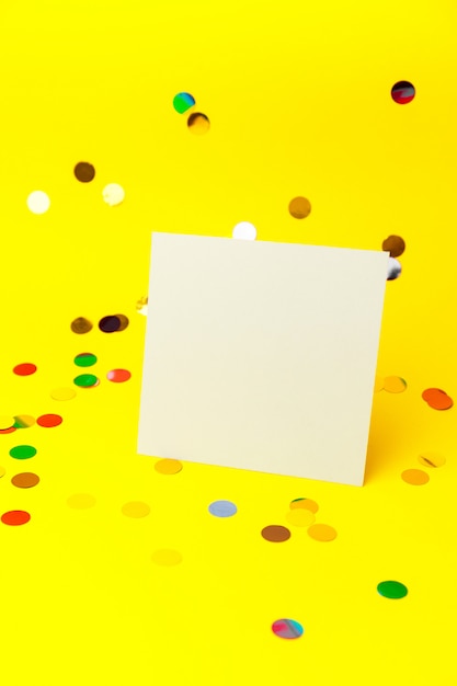 Blank White page mock up and sparkles confetti on Yellow.