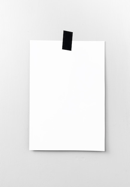 Blank white poster hanging on a tape on the wall. Template background for your design.