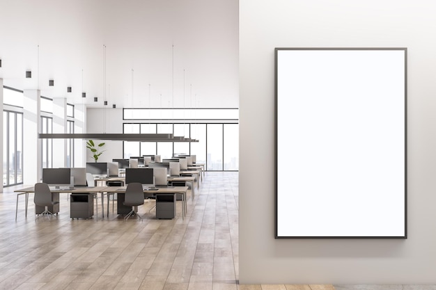 Blank white poster on light wall with place for your logo in spacious sunlit office area with cozy workspaces high ceiling panoramic windows with city view and wooden floor 3D rendering mockup