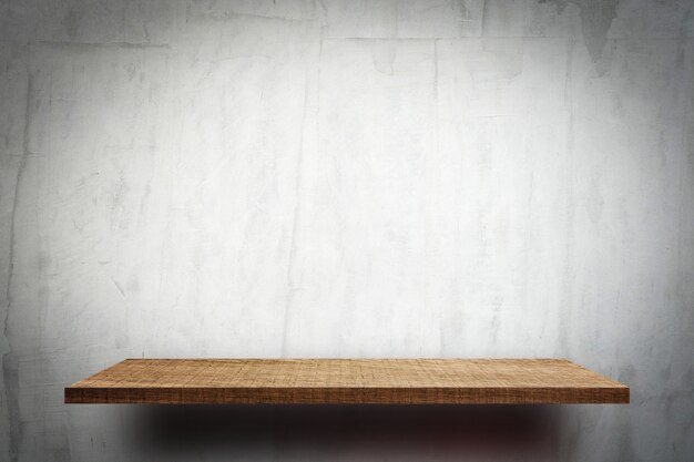 Blank wooden display shelf on white cement wall