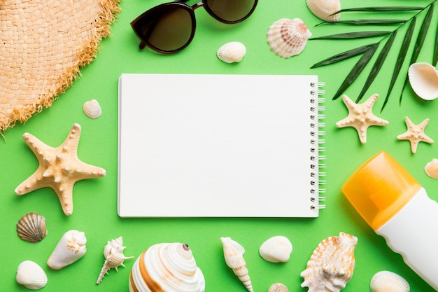 Blank writing book with summer beach accessories on background copy space Flat lay with copy space