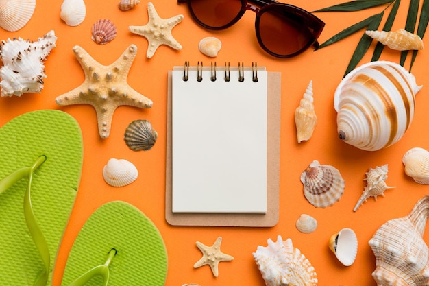 Blank writing book with summer beach accessories on background copy space Flat lay with copy space