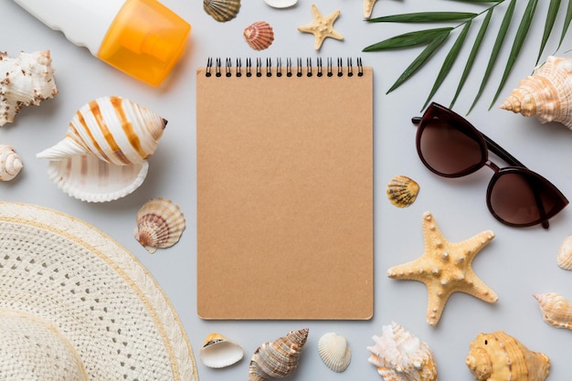 Blank writing book with summer beach accessories on background copy space Flat lay with copy space