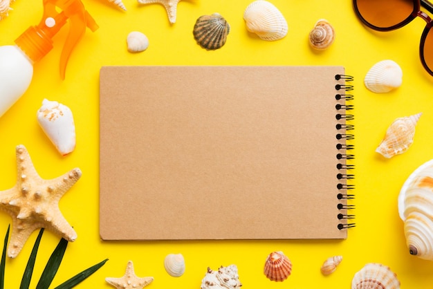 Blank writing book with summer beach accessories on background copy space Flat lay with copy space