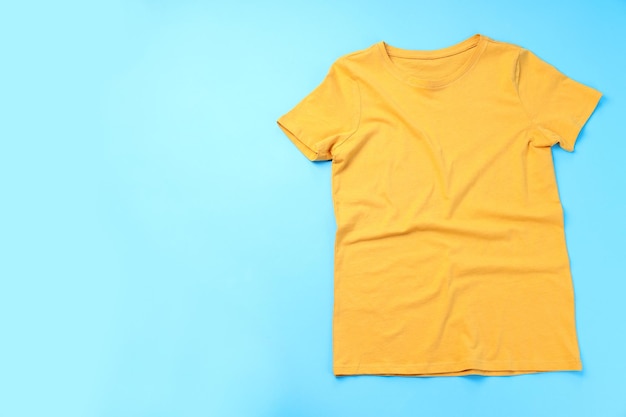 Blank yellow t-shirt with space for print on blue background