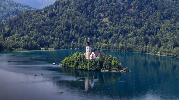 Photo bled lake slovenia island with pilgrimage church reflected in water mountains in background