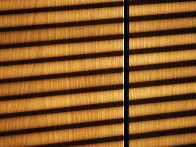 Blinds shadow on wooden wall background