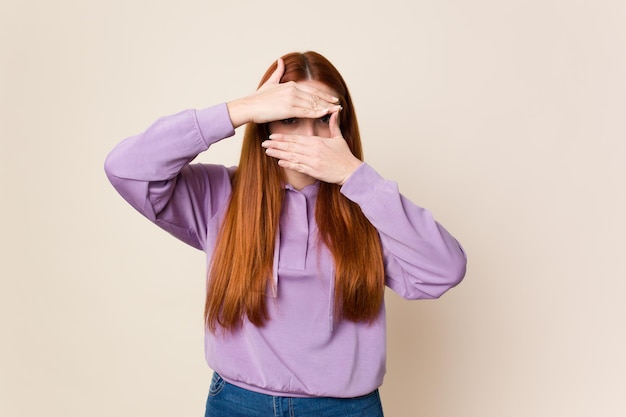 Blink at the camera through fingers embarrassed covering face