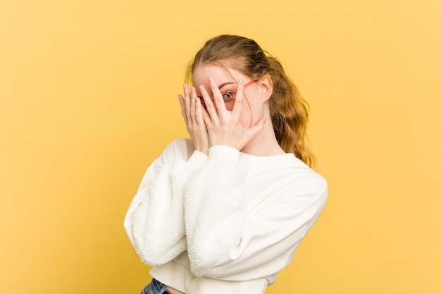 Blink at the camera through fingers embarrassed covering face