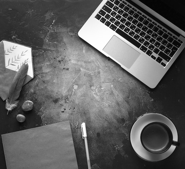 Blog style, Laptop and notebook with coffee on a dark background, Black and white