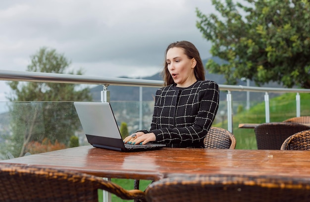 Blogger girl is working on laptop on nature view background