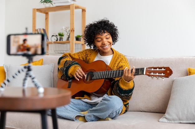 Blogger guitarist happy african american girl blogger playing guitar singing song recording vlog soc