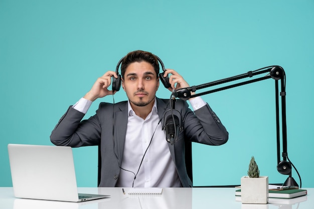 Blogger journalist cute handsome young guy in grey suit recording video in headset