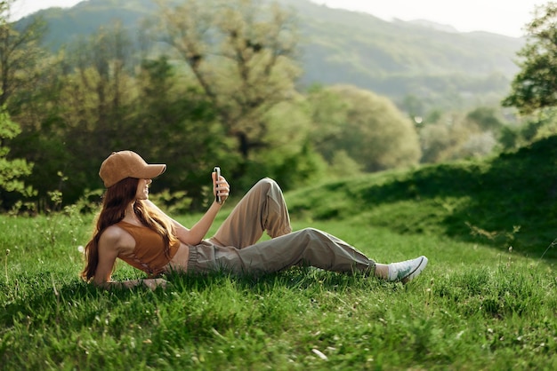 Blogger with phone working in park on grass by tree freelancer lifestyle