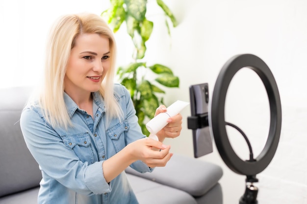 blogger woman records video with round lamp.