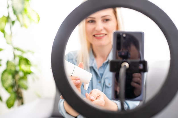 blogger woman records video with round lamp.