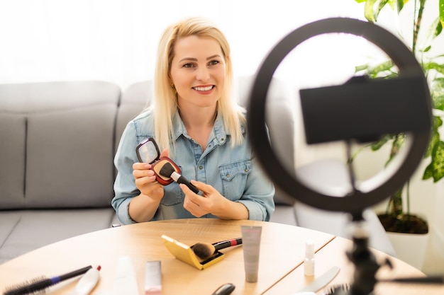 blogger woman records video with round lamp.