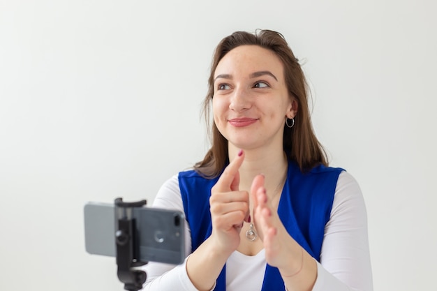 Photo blogging, broadcast and people concept - woman blogger is talking to the camera for her spectators.