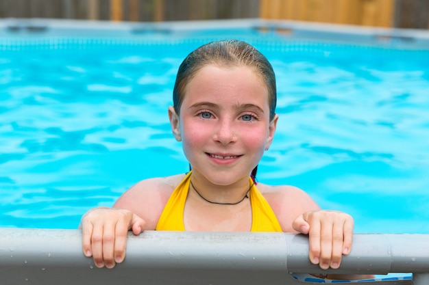 Blond girl swimming in the pool with red cheeks