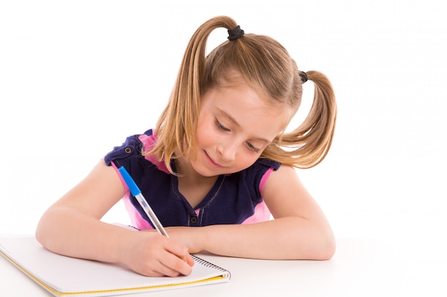 Photo blond kid girl student with spiral notebook in desk