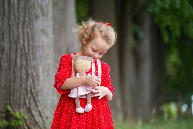 a blond preschool girl in a wreath of rowan and with toys