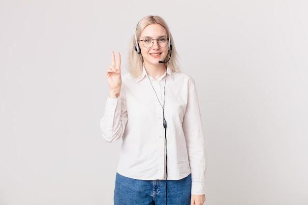 Blond pretty woman smiling and looking friendly, showing number two telemarketing concept