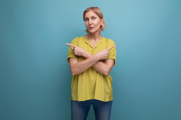 Blond s woman showing her finger on the blank space of the wall