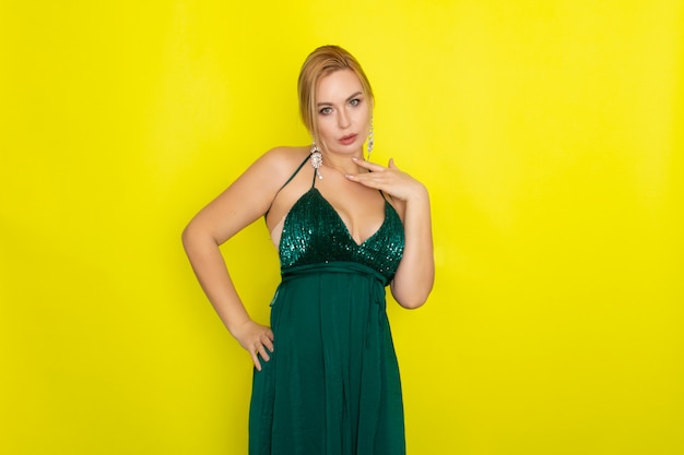 Blond woman wearing green evening dress over yellow